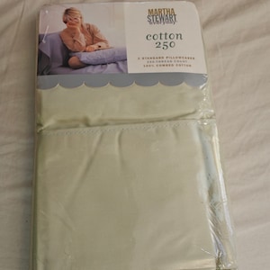 May include: A packaged set of Martha Stewart Everyday cotton bed sheets. The packaging features a woman on a couch and the text "cotton 250". The set includes two standard pillowcases and is 100% combed cotton.