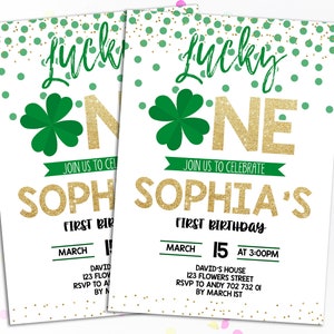 Puede incluir: Dos invitaciones para una celebraci&oacute;n de primer cumplea&ntilde;os. El dise&ntilde;o presenta el texto "Lucky One" en verde y purpurina dorada, con un tr&eacute;bol y confeti. La invitaci&oacute;n dice "&Uacute;nase a nosotros para celebrar el primer cumplea&ntilde;os de Sophia."