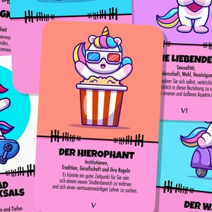 May include: A set of tarot cards with colorful unicorn illustrations and German text. The cards feature a variety of themes, including justice, love, the hierophant, and the chariot.