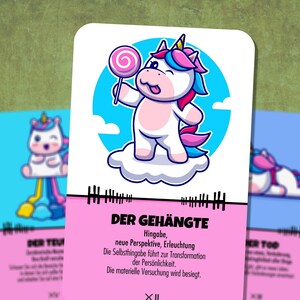 May include: A pink and blue unicorn card with the text "DER GEH&Auml;NGTE" and the text "Hingabe, neue Perspektive, Erleuchtung. Die Selbsthingabe f&uuml;hrt zur Transformation der Pers&ouml;nlichkeit. Die materielle Versuchung wird besiegt. XII". The unicorn is holding a pink lollipop and is standing on a white cloud.