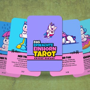 May include: Five colorful tarot cards with unicorn illustrations. The cards are from the "Das Erwachte Einhorn Tarot" deck and feature the following titles: "Der Turm", "Der Teufel", "Der Tod", "M&auml;ssigkeit", and "Das Erwachte Einhorn Tarot Grosse Arkana".