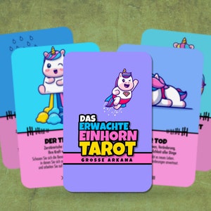 May include: A set of tarot cards featuring a unicorn theme. The cards are purple, pink, and blue with illustrations of unicorns in various poses. The text on the cards reads "Das Erwachte Einhorn Tarot" and "Grosse Arkana".