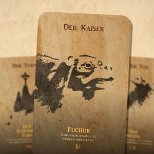 May include: A vintage-style tarot card with a black and white illustration of a creature's head. The card is titled "Der Kaiser" and has the text "Fuchur Struktur, Stabilität Regeln und Macht IV" on the bottom.