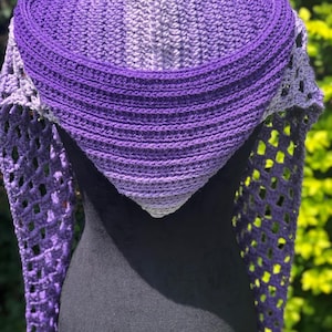 May include: A purple and gray ombre crochet shawl with a lacy design. The shawl is draped over a black mannequin.