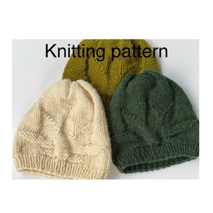 May include: Three knitted beanies in cream, olive green, and dark green. The cream beanie has a textured pattern. The text "Knitting pattern" is above the beanies. These handmade hats are perfect for cold weather.