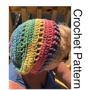 May include: A rainbow crochet hat with a unique open stitch pattern. The hat is made with a variety of colors, including red, orange, yellow, green, blue, and purple.