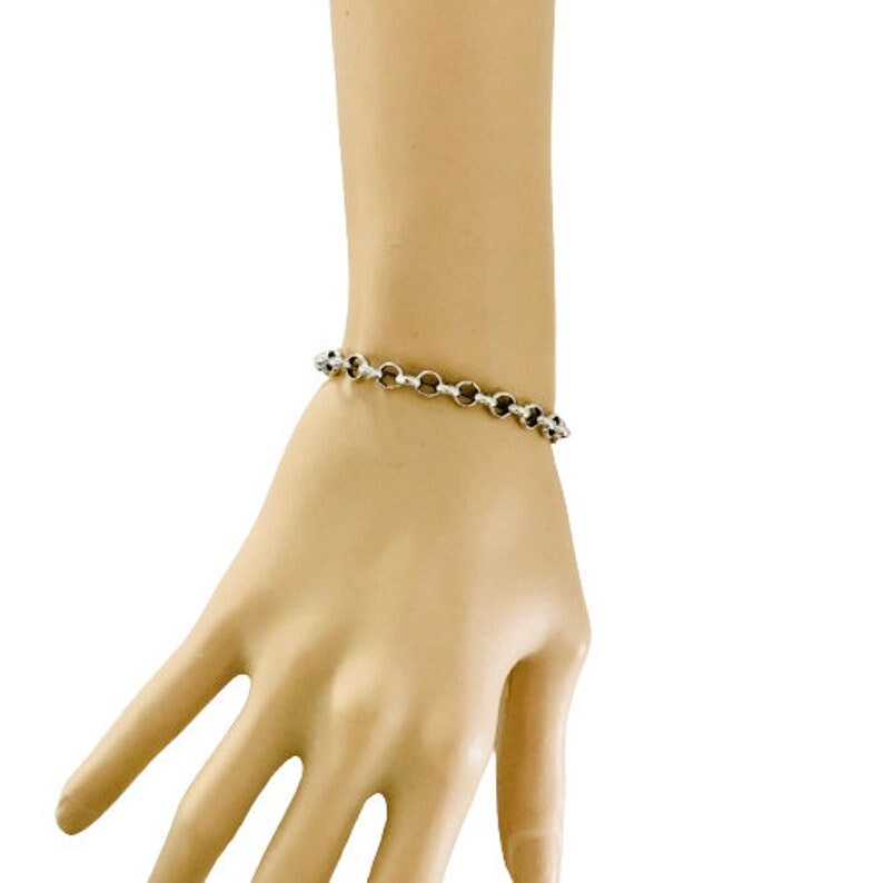 May include: A silver chain bracelet with a simple, classic design.