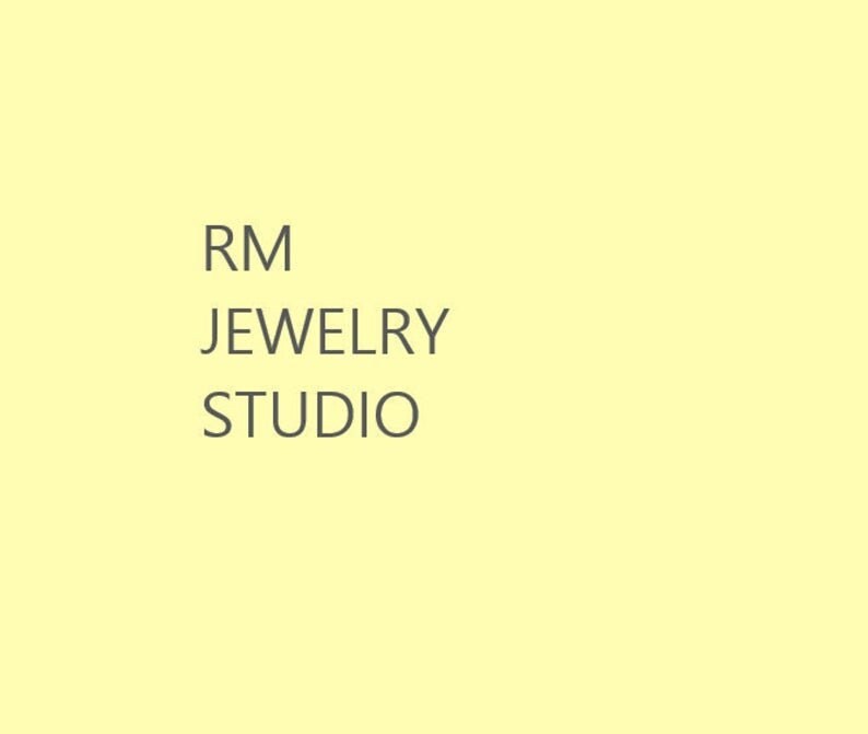 May include: RM Jewelry Studio logo with the text "RM Jewelry Studio" in a grey font on a pale yellow background.