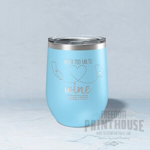 May include: A light blue stainless steel wine tumbler with a silver design that says "Never too far to wine together" with an outline of California and Georgia connected by a dotted line with a heart in the middle.