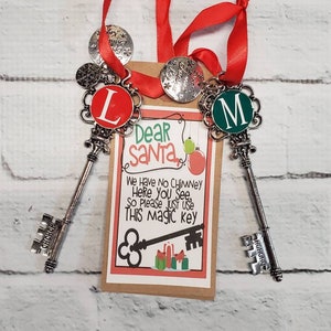 May include: Two silver skeleton keys with red and green letter charms, attached to a red ribbon and a brown card with the text "Dear Santa, We Have No Chimney Here You See, So Please Just Use This Magic Key".