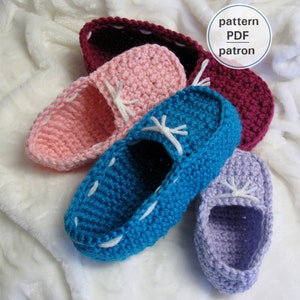 May include: Four crocheted slipper shoes in different colors: pink, blue, purple, and burgundy. The shoes have white laces and are laid out on a white fluffy surface. The text "pattern PDF patron" is visible in the upper right corner of the image.