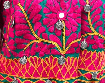 May include: A green and pink embroidered jacket with silver coin embellishments. The jacket has a V-neck and a button closure.