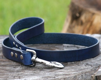 Puede incluir: Una correa de perro de cuero azul oscuro con un clip plateado y tachuelas metálicas.