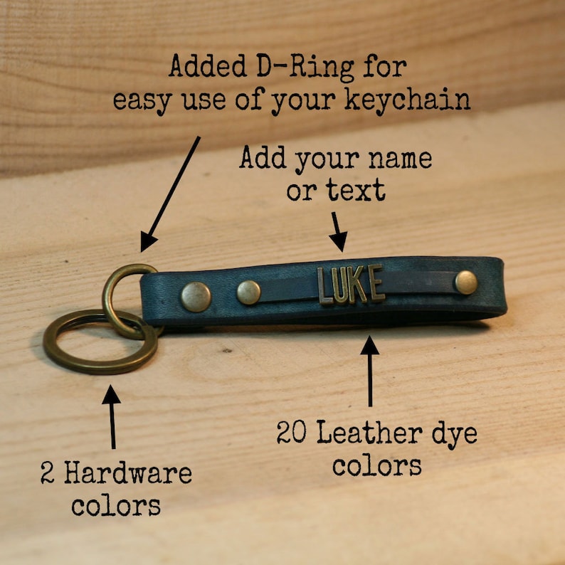 May include: A blue leather keychain with a brass D-ring and two brass rivets. The keychain has a brass plate with the name "LUKE" engraved on it. The keychain is available in 20 leather dye colors and 2 hardware colors.