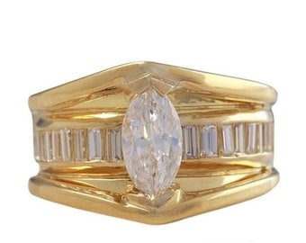 May include: A gold ring with a marquise-shaped diamond set in the center. The band is adorned with a row of smaller baguette-shaped diamonds.