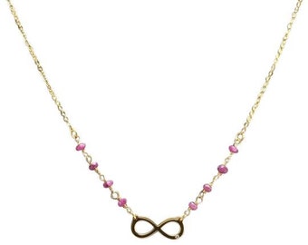 Op de afbeelding: Gouden ketting met een oneindigheidssymbool bedel en roze edelsteen accenten.