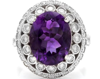 May include: A silver ring featuring a large oval amethyst gemstone encircled by a halo of smaller round diamonds.