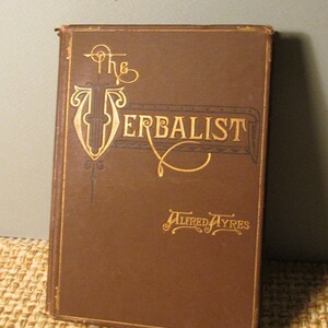 May include: A brown book with gold lettering on the cover. The title is "The Verbalist" and the author is "Alfred Ayres".