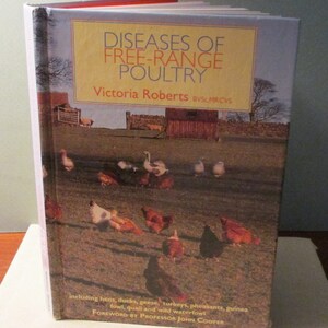 May include: A book cover with a yellow and orange title that reads "Diseases of Free-Range Poultry" by Victoria Roberts BVSC.MRCVS. The cover features a photograph of a grassy field with a variety of poultry, including chickens, ducks, and geese.