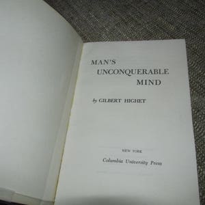 May include: A white book with the title "Man's Unconquerable Mind" by Gilbert Highet. The book is published by Columbia University Press in New York.