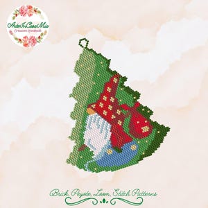 Può includere: Un ornamento a forma di gnomo in perline verdi, rosse e blu con un cappello rosso e una barba bianca. Lo gnomo tiene una borsa rossa. L'ornamento è realizzato con punto peyote ed è pronto per essere utilizzato per le decorazioni natalizie.