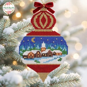 Puede incluir: Un adorno navideño de cuentas con una escena de pueblo invernal, casas cubiertas de nieve, una luna creciente y estrellas. El adorno tiene una parte superior geométrica roja y dorada, un panel central azul y una base roja y dorada en punta.