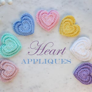 May include: A set of seven crocheted heart appliques in various pastel colors, including light blue, teal, pink, yellow, white, and lavender. The hearts are layered and have a textured appearance. The text "Heart Appliques" is written in a decorative font below the hearts.