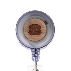 May include: A black retractable badge holder with a wooden insert featuring a laser-engraved hamburger icon.