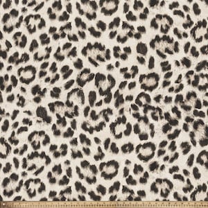 May include: A white fabric with a black leopard print pattern. The fabric has a soft, fuzzy texture.