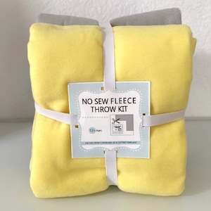 May include: A yellow fleece throw kit with a white label that says "No Sew Fleece Throw Kit" and "12+ Ages". The kit is wrapped with white elastic bands.