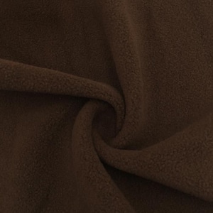 May include: Close-up of a brown fleece fabric with a soft, textured surface. The fabric is folded and draped, showing the depth and texture of the material. The colour is a rich, warm brown.