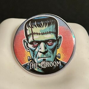 May include: A round button with a colorful graphic of Frankenstein's monster. The text "The Groom" is printed below the image.
