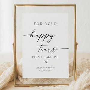 May include: A rectangular sign in a thin gold metal frame featuring the black printed text FOR YOUR happy Tears PLEASE TAKE ONE with a small heart symbol and the names Susan and Andrew with the date 09.09.20XX on a white background.