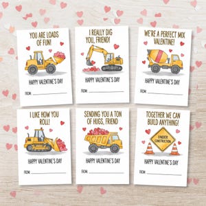 May include: Six Valentine's Day cards with construction vehicle illustrations. Each card features a different vehicle, such as a bulldozer, excavator, and cement mixer, carrying heart-shaped objects. The cards have the text "Happy Valentine's Day".