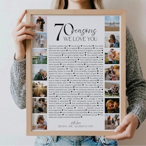 May include: A framed print with the text "70 Reasons We Love You" and several small photos. The print is held by a person. The text includes a list of reasons, and the names "Susan, Joe, Allison & Amy" are at the bottom.