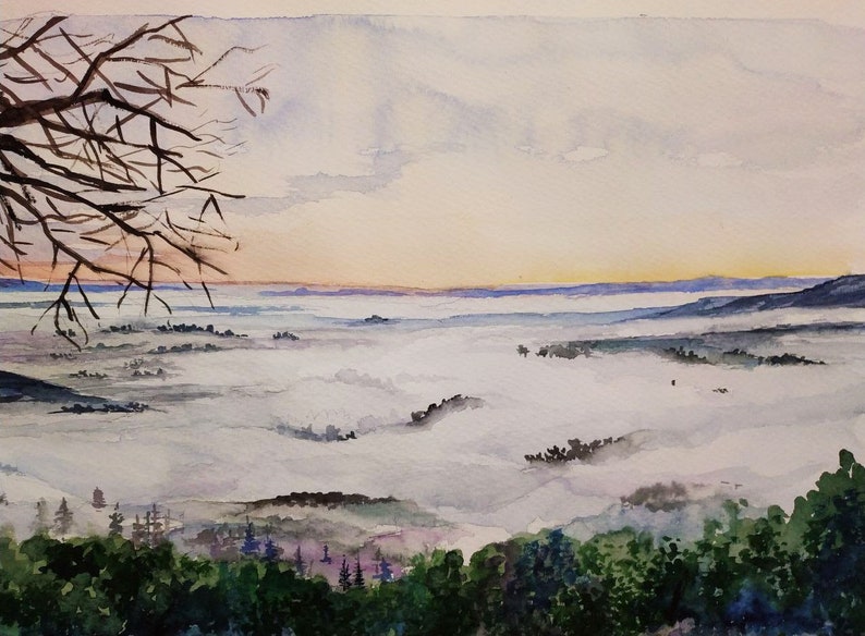 Op de afbeelding: Een aquarel schilderij van een mistig landschap met een tak van een boom op de voorgrond. De lucht is zacht roze en oranje, en de mist is licht grijs. De bomen in de verte zijn donkergroen.