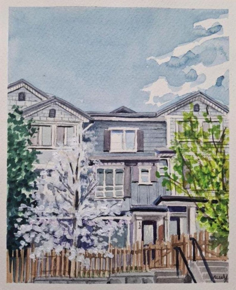 Op de afbeelding: Waterverf schilderij van een huis met een wit houten hek en een bloeiende boom in de voortuin. Het huis is grijs met witte versiering en heeft een veranda met een deur. De lucht is blauw met witte wolken.
