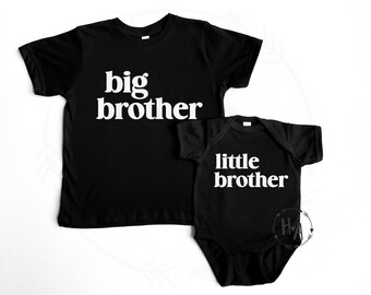 May include: Two black t-shirts with white text. The larger shirt says "big brother" and the smaller shirt says "little brother".