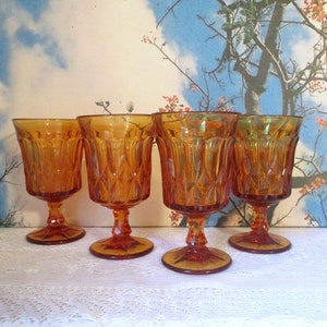 Puede incluir: Juego de cuatro copas de vidrio ámbar con un patrón de diamante. Las copas tienen una base con tallo y son perfectas para servir vino u otras bebidas.