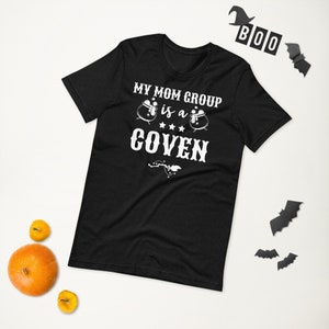 May include: Black t-shirt with white text that reads "My Mom Group is a Coven" with two cauldron graphics.