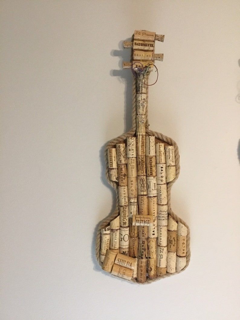 Pu&ograve; includere: Un violino realizzato con tappi di sughero per vino, con un bordo di corda e una variet&agrave; di etichette di sughero, tra cui "BAYONETTE", "SALDO", "VINTAGE" e "SHIDA".