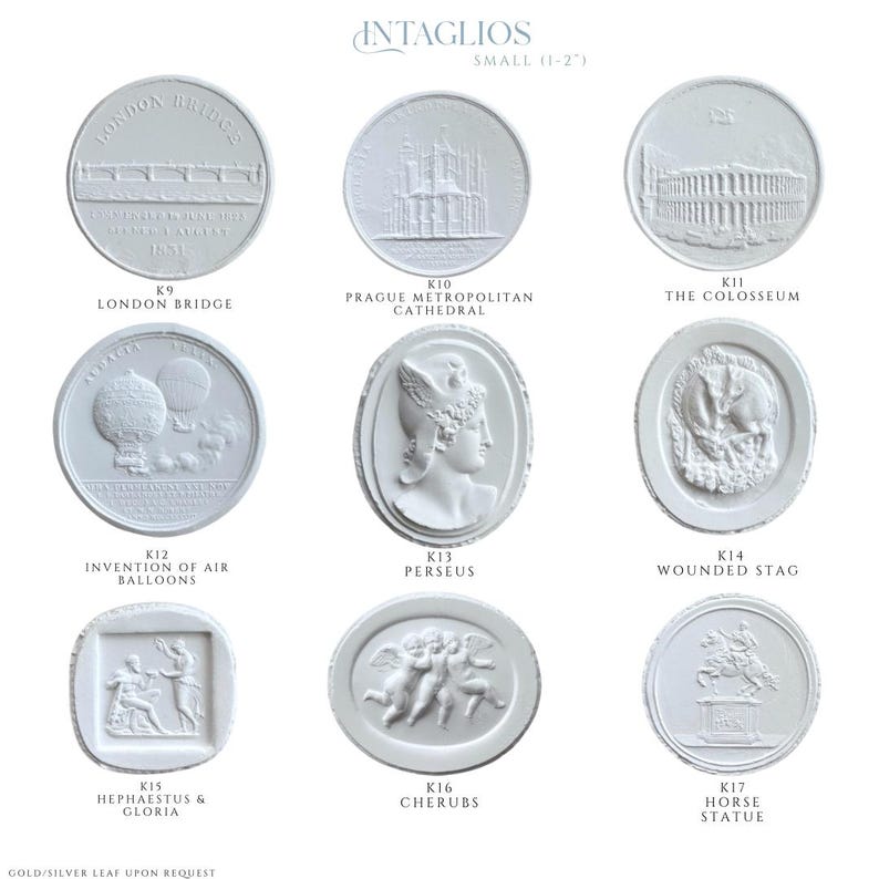 May include: A collection of small, white intaglio plaques, each featuring a different classical design. Designs include the London Bridge, Prague Metropolitan Cathedral, the Colosseum, and cherubs. The text "INTAGLIOS SMALL (1-2")" is at the top.