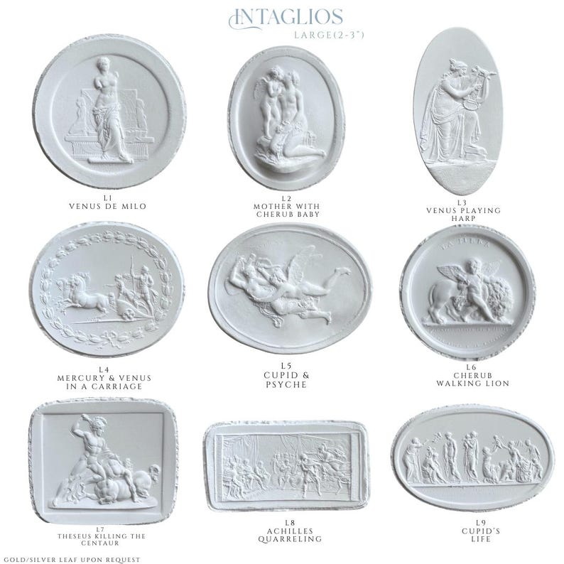 May include: A collection of white plaster intaglios, each featuring classical relief sculptures. The designs include Venus de Milo, Cupid and Psyche, and scenes of mythological figures. The intaglios are large, measuring 2 to 3 inches.