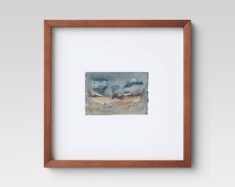 May include: A framed watercolor painting of a landscape with a cloudy sky and a field in the foreground. The colors are muted and the painting has a soft, dreamy feel.