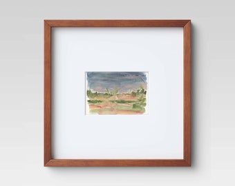 May include: A framed watercolor landscape painting. The artwork features a field with green and orange hues, a blue and purple sky, and a brown wooden frame. The painting is mounted on a white mat.