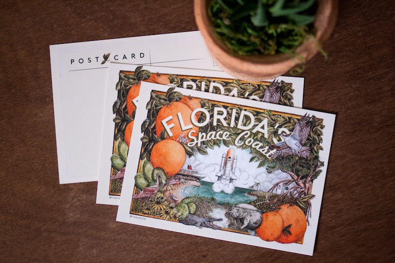 May include: A postcard featuring a colourful illustration of Florida's Space Coast. The postcard depicts a space shuttle launching, a beach scene, and various Florida wildlife, including an alligator, a manatee, and a bird. The text "Florida's Space Coast" is written in a stylised font.