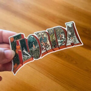 May include: A sticker with the word "FLORIDA" in large, stylized letters. Each letter is filled with a different vintage illustration, including oranges, birds, and other Florida scenes. The letters are outlined in red.