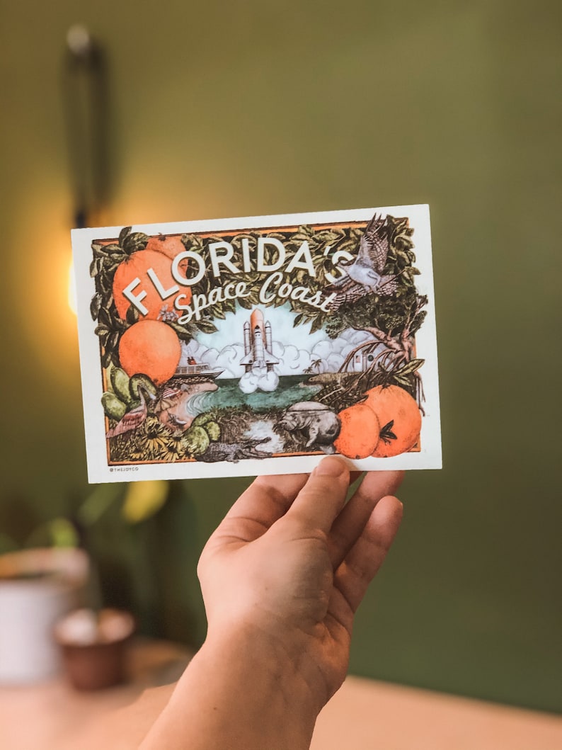 May include: A vintage-style illustration of a space shuttle launching from a Florida Space Coast landscape. The illustration features oranges, palm trees, and a bird in flight. The text "FLORIDA'S Space Coast" is printed in a retro font.