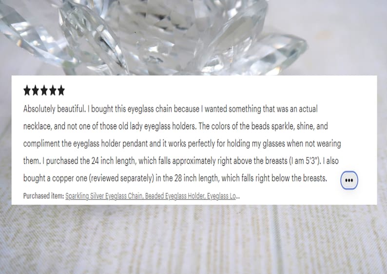 May include: A close-up of a clear, faceted crystal object with a review of a beaded eyeglass chain. The review text mentions a 24-inch chain and a 28-inch chain. The text also mentions the item purchased: Sparkling Silver Eyeglass Chain, Beaded Eyeglass Holder.