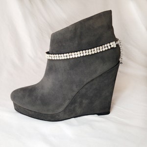 May include: Gray suede wedge ankle boots with a rhinestone ankle strap.